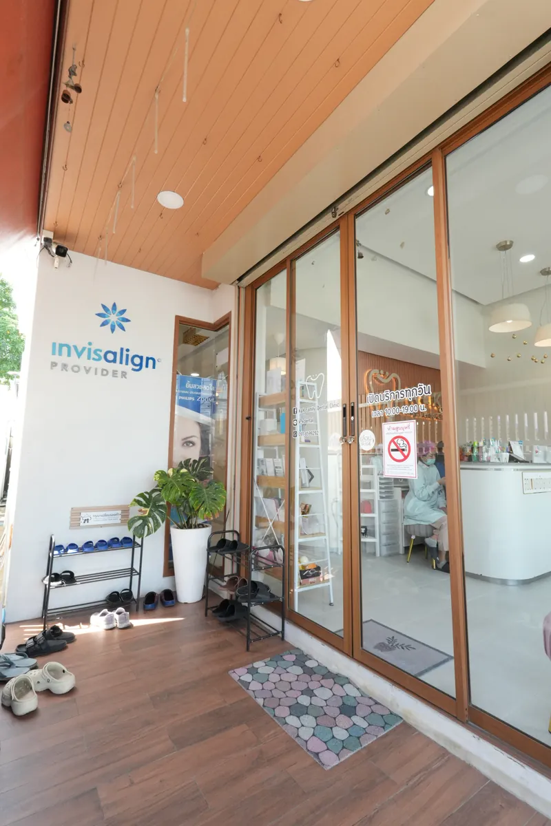 หน้าคลินิกทันตกรรม เค แอนด์ เค ปากซอยห้วยใหญ่ นาจอมเทียน — ระเบียงไม้ ประตูกระจก และชั้นวางรองเท้าหน้าร้าน