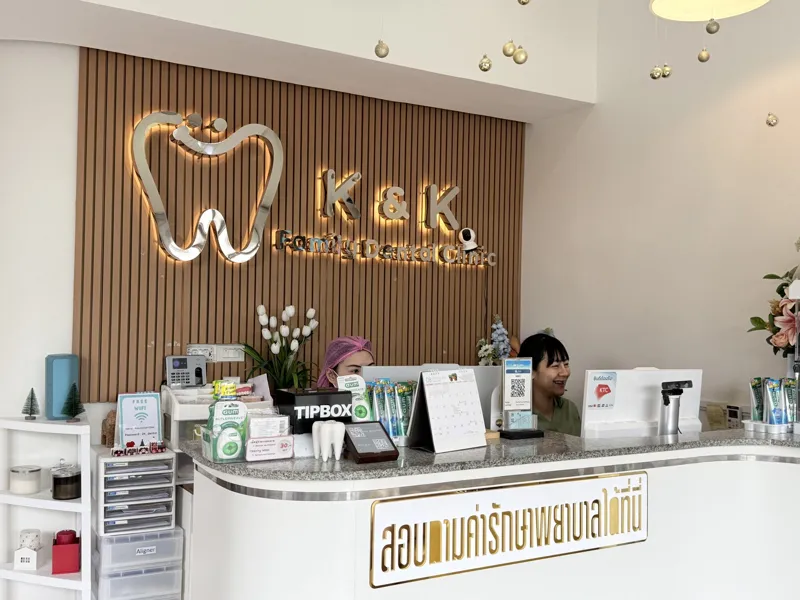 The reception desk, with the K&K logo lit on the timber-batten wall behind it