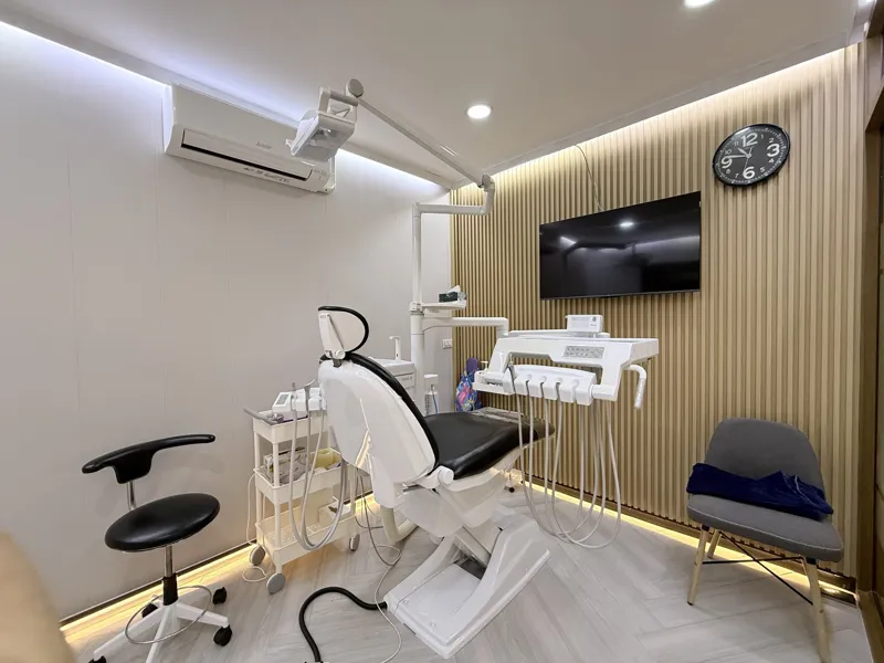 A treatment room with a timber-batten wall and a screen showing an X-ray